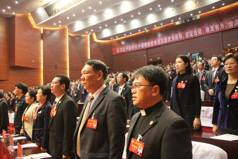 市政协十届四次会议开幕，全体起立，奏唱国歌。